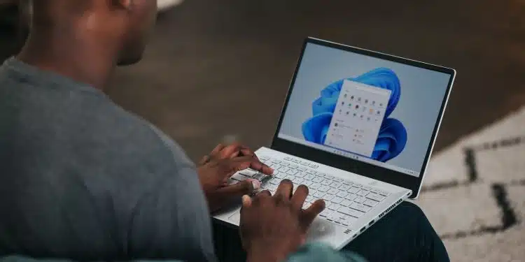 man in gray long sleeve shirt using Windows 11 computer