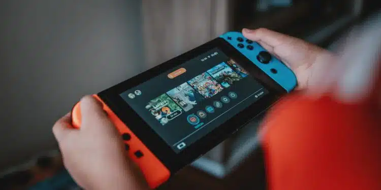 person holding black and orange nintendo switch